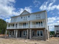 New townhouse with white siding, brick foundation, and welcoming covered balconies at 221 Village Overlook # H2, Canton, GA 30114