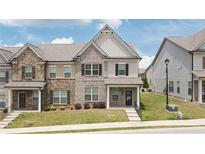 Charming two-story townhome with a well-maintained lawn and inviting front entrance at 2692 Pearl Ridge Trce, Buford, GA 30519