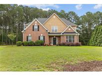 Charming two-story brick home with a well-manicured lawn and mature trees at 3 Tiffany Trce, Palmetto, GA 30268