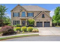 Beautiful brick home featuring a manicured front yard and attached two-car garage at 3179 Falls Crest Ct, Buford, GA 30519