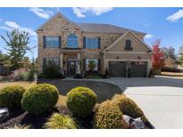 Charming two-story brick home with a well-manicured front yard and an attached two-car garage at 3179 Falls Crest Ct, Buford, GA 30519