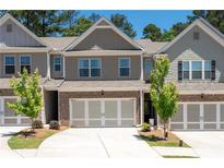 Charming townhome with a two-car garage, neutral siding, and a well-manicured front yard at 213 Yellowwood Way, Woodstock, GA 30188