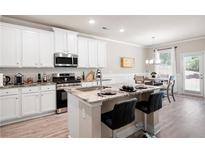 Modern kitchen with white cabinets, stainless steel appliances, and granite countertops at 213 Yellowwood Way, Woodstock, GA 30188
