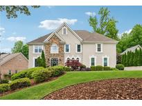 Charming two-story home with stone accents, manicured landscaping, and a lush green lawn at 641 Lake Overlook Dr, Canton, GA 30114