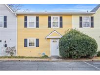 Charming yellow townhouse featuring black shutters and a well-manicured front yard at 2858 Spring Villa Se Ln, Smyrna, GA 30080