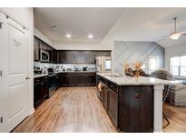 Spacious kitchen featuring dark wood cabinets, granite countertops, and stainless steel appliances at 64 Citadel Dr, Hampton, GA 30228