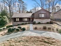 Charming exterior features wood and stone accents, landscaped yard, and inviting front porch at 1905 Castleway Ne Ln, Atlanta, GA 30345