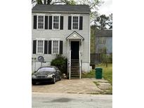 Two story home with gray siding, black shutters, front yard, and a staircase leading to the front door at 3464 Kingswood Trl, Decatur, GA 30034