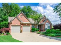 Charming brick home featuring a well-manicured lawn, two-car garage, and beautiful landscaping at 1460 Badingham Dr, Cumming, GA 30041