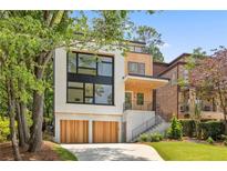 Modern home with a two-car garage and a combination of light-colored siding and wood panels at 1287 Star Ne Dr, Brookhaven, GA 30319