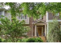 Charming brick townhome featuring a welcoming front porch and lush landscaping at 855 Mountain View Nw Ter, Marietta, GA 30064
