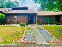 Charming single-story brick home with well-manicured lawn and landscape details along the walkway at 1520 Stoneleigh Cir, Stone Mountain, GA 30088