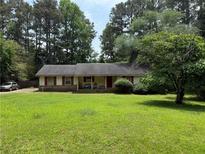 Charming single-story home featuring red shutters and a sprawling green lawn at 108 Fair Oaks Se Dr, Conyers, GA 30094