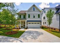 Charming gray two-story home with well-manicured lawn, concrete driveway and inviting front porch at 138 Beutell St, Norcross, GA 30071