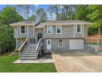Charming two-story home features a gray exterior, attached garage, and inviting front porch with steps at 300 Rocky Cove Trl, Lawrenceville, GA 30044