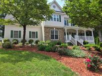 Beautiful two-story home with stone accents, a large porch, and professionally landscaped front yard at 811 Millvale Pl, Lawrenceville, GA 30044