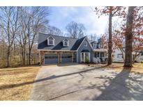 Charming blue two-story home with a stone garage and a well-maintained front yard at 1931 Amber Dawn Way, Lawrenceville, GA 30043