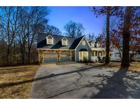 Charming two-story home with blue siding, stone accents, dormer windows and attached two-car garage at 1931 Amber Dawn Way, Lawrenceville, GA 30043