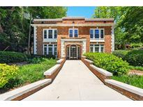 Attractive brick building with symmetric window placement and professionally landscaped entry at 242 12Th Ne St # 1A, Atlanta, GA 30309