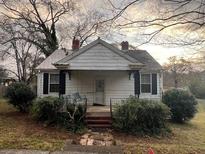 Charming bungalow home featuring a covered front porch and mature landscaping at 5111 Newark Ave, Clarkdale, GA 30111