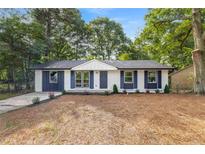 Charming exterior with a well-manicured lawn, fresh exterior paint and complementary landscaping at 6932 Eunice Dr, Riverdale, GA 30274