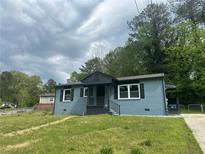 Charming single-story home with light blue brick, black trim, and a well-maintained front yard at 3730 Clovis Nw Ct, Atlanta, GA 30331