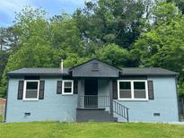 Charming single-story home with a newly painted brick facade, black shutters, and a modern metal roof at 3730 Clovis Nw Ct, Atlanta, GA 30331