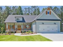 Charming, light blue, one-story home with a welcoming front porch and an attached two-car garage at 85 Presley Farm Pkwy, Rockmart, GA 30153
