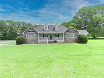 Charming stone-accented home featuring a welcoming front porch and manicured lawn at 2759 Bay Ridge Dr, Loganville, GA 30052