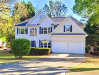 Charming two-story home featuring blue shutters, a manicured lawn, and a two-car garage at 505 Tilbury Dr, Suwanee, GA 30024