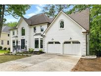 Beautiful two-story painted brick home with a two-car garage, arched windows, and well-maintained landscaping at 12230 Asbury Park Dr, Roswell, GA 30075