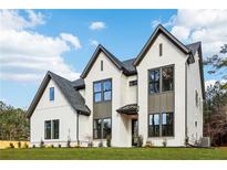 Striking white brick home featuring black trim, complemented by a well-manicured lawn and inviting curb appeal at 3735 Tamiami Trl, Cumming, GA 30041