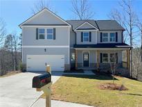 Charming two-story home featuring a well-manicured lawn, attached two-car garage, and inviting front porch at 5342 Legacy Trl, Douglasville, GA 30135