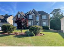 Charming two-story home with landscaped yard and brick and stone exterior, perfect for curb appeal at 582 Georgia Cir, Loganville, GA 30052