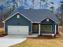 Charming home with a two-car garage, inviting entryway, and well-manicured front yard at 5295 Greenway Dr, Villa Rica, GA 30180
