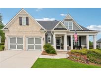 Charming craftsman style home featuring a brick and siding facade, attached garage, and inviting front porch with manicured lawn at 1974 Hosack Sw Hl, Marietta, GA 30064