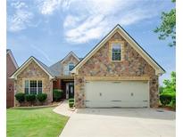 Charming stone and siding home featuring a two-car garage and manicured lawn at 9157 Golfview Cir, Covington, GA 30014