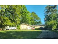 Ranch home with mature trees and a long driveway at 2579 Country Club Dr, Conyers, GA 30013