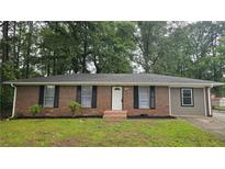 Charming single-story brick home featuring classic shutters and a well-maintained front yard at 679 Winchester Ln, Norcross, GA 30071