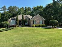 Beautiful brick home with a well-manicured front yard and mature landscaping at 1305 Lake Forest Ln, Mcdonough, GA 30253