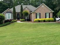 Charming brick home with a beautifully manicured lawn and mature landscaping at 1305 Lake Forest Ln, Mcdonough, GA 30253