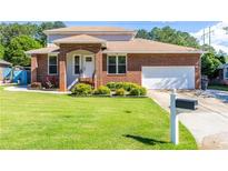 Charming brick home with well-manicured lawn and an attached two-car garage at 1480 Shady Cove Ln, Lawrenceville, GA 30043