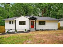 Charming home with a red door, landscaped yard, and fresh white paint at 1599 Sandtown Rd, Atlanta, GA 30311