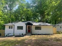 Charming renovated bungalow with white siding, a red door, and a well-maintained front yard at 1599 Sandtown Rd, Atlanta, GA 30311