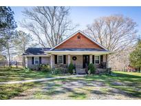 Charming brick home featuring a cozy front porch and a decorative star above the entrance at 689 Hardin Rd, Temple, GA 30179