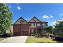 Charming two-story brick home featuring a well-manicured lawn and attached two-car garage at 3360 Keenland Rd, Marietta, GA 30062