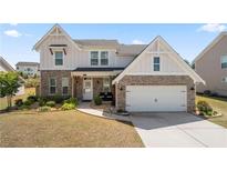 Charming two-story home featuring brick and vinyl siding, a well-manicured lawn and attached two-car garage at 4607 Underwood Walk, Powder Springs, GA 30127