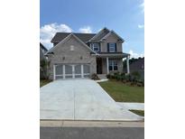Charming two-story home with brick exterior, a large driveway, and well-manicured lawn at 4297 Azalea Ridge Way, Hoschton, GA 30548