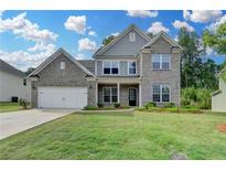 Beautiful two-story home with gray brick, attached garage, and well-manicured lawn at 5215 Wheeler Run Dr, Auburn, GA 30011