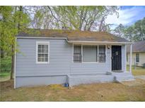 Modest single-story home with gray siding, black security door, and visible signs of wear and tear at 2293 Ewing Sw St, Atlanta, GA 30331
